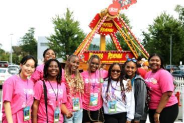 7 pack leaders standing together for photo in front of a ride.