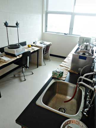 Clean sample preparation lab containing balances, automatic sieving and weighing column, Elmasonic S300 ultrasonic cleaner for sieve cleaning, McCrone micronizing mill, and a Retsch microball mill with agate, stainless steel, ceramic and tungsten carbide ball mills. Used for grinding, weighing and sizing geological samples. Contact: Randy Corney