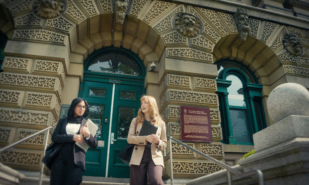Two students walk out of the courthouse with work documents