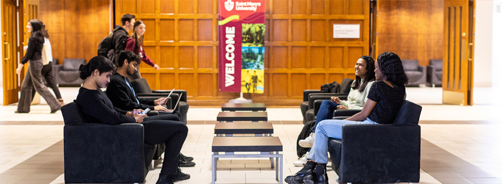 A mix of students sit in chairs inside the McNally lobby. A SMU banner reads Welcome in the background.