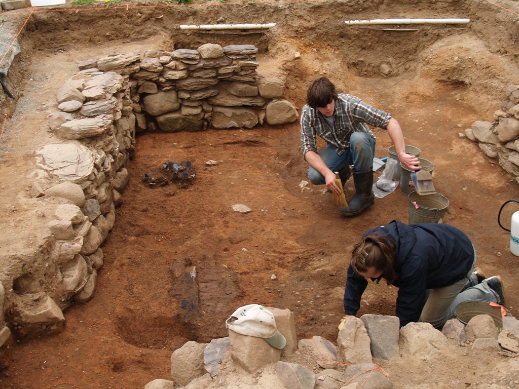Students excavating the occupation layer of a burned pre-Deportation Acadian house at Grand-Pré National Historic Site. We located this stone-lined cellar with the aid of geophysics.