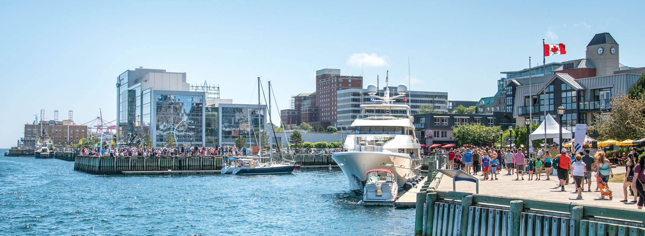 Halifax Waterfront showing the ocean with various boats docked with the city in the background