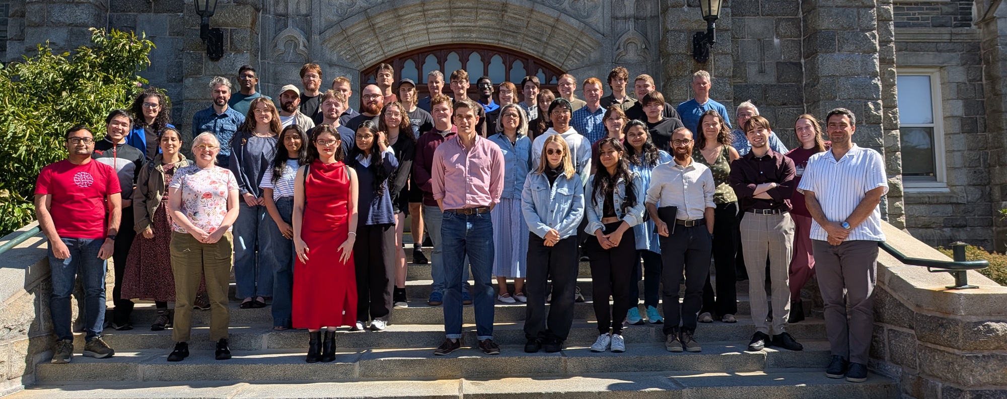 Members of Astronomy & Physics standing on stairs in front of a building