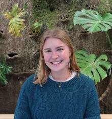Photographic portrait of Maggie Rodwell in front of the living wall in the Atrium