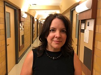 A photo of Dr. Sara Malton standing in a hallway in the McNally Building.
