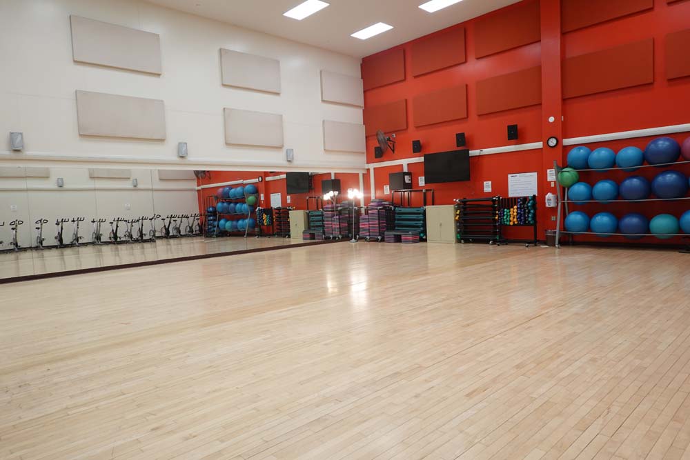 Studio C. Large dance style studio with fitness equipment against the back wall