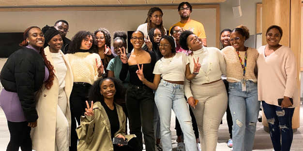 A group of Black students pose together at an event