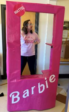 Emma McClure poses inside a photo booth in the shape of a Barbie box.